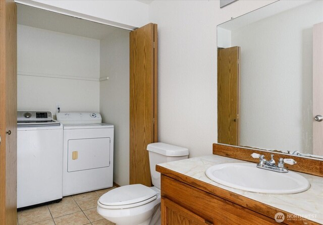 111 NW Columbia Dr Unit B7, Oak Harbor, WA 98277 - bathroom featuring washer and clothes dryer, toilet, vanity, and tile patterned flooring