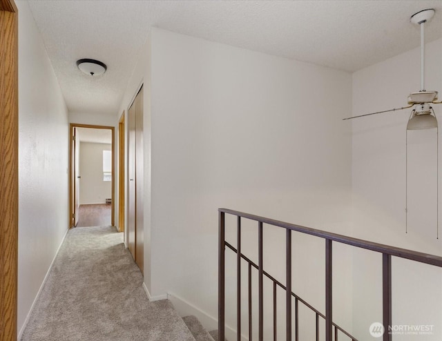 111 NW Columbia Dr Unit B7, Oak Harbor, WA 98277 - corridor featuring carpet flooring, a textured ceiling, and baseboards
