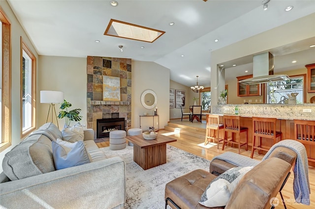 3222 107th Ave SE, Bellevue, WA 98004 - living area featuring a skylight, light wood-type flooring, a tile fireplace, vaulted ceiling, and a chandelier