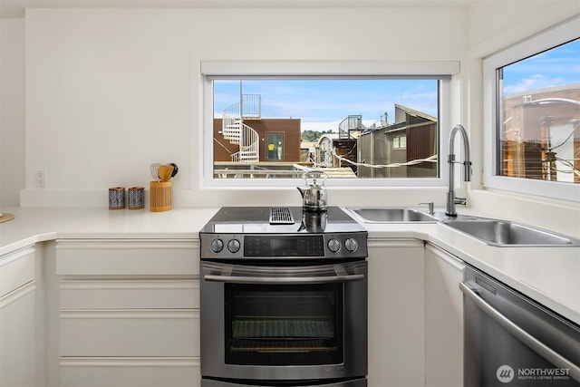2031 Fairview Ave E Unit E, Seattle, WA 98102 - kitchen featuring stainless steel appliances, white cabinetry, a sink, and light countertops