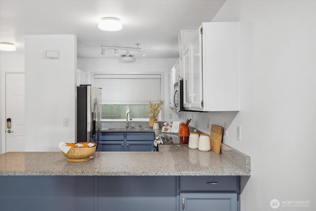 12307 NE 97th St Unit B, Kirkland, WA 98033 - kitchen with appliances with stainless steel finishes, a sink, white cabinets, and blue cabinetry