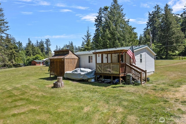 1269 Hideaway Ln, Oak Harbor, WA 98277 - back of house featuring a lawn, a deck, metal roof, and view of scattered trees