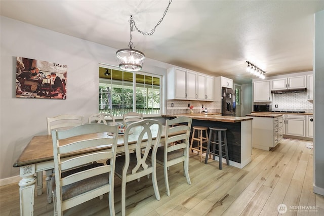 15329 Mckee Ln SE, Yelm, WA 98597 - dining space with light wood-style flooring, a chandelier, and baseboards