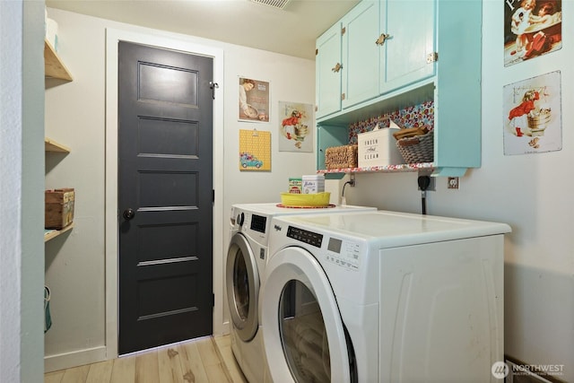 15329 Mckee Ln SE, Yelm, WA 98597 - washroom with separate washer and dryer, cabinet space, light wood finished floors, and baseboards