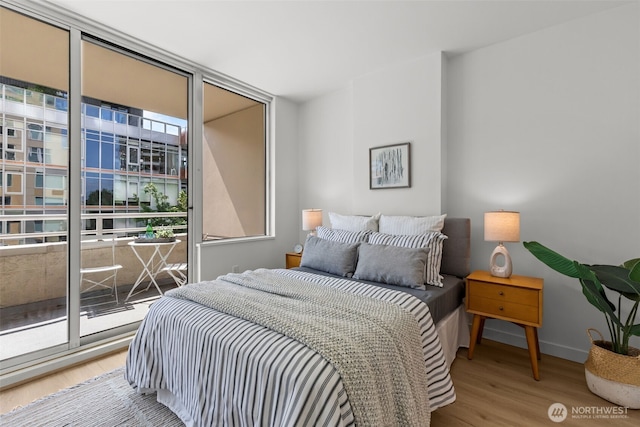 2600 2nd Ave Unit 504, Seattle, WA 98121 - bedroom featuring wood finished floors, expansive windows, and baseboards