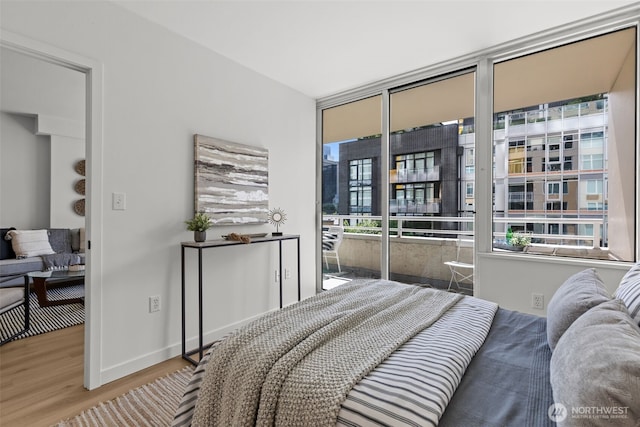 2600 2nd Ave Unit 504, Seattle, WA 98121 - bedroom featuring wood finished floors, a wall of windows, access to outside, and baseboards