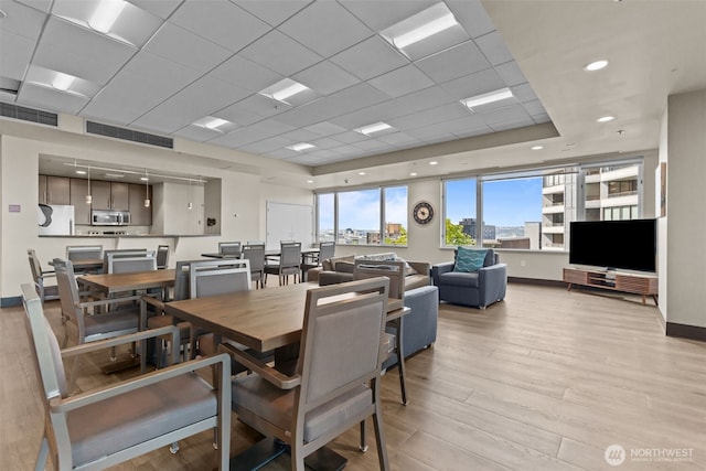 2600 2nd Ave Unit 504, Seattle, WA 98121 - dining space with light wood-style flooring, baseboards, and a drop ceiling