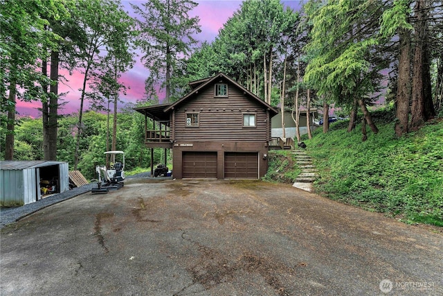 214 Inglewood Dr, Longview, WA 98632 - property exterior at dusk with asphalt driveway, log exterior, and an attached garage