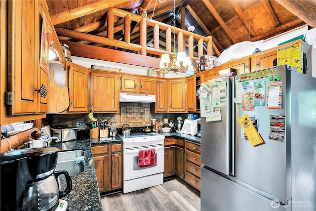 214 Inglewood Dr, Longview, WA 98632 - kitchen featuring freestanding refrigerator, white electric stove, under cabinet range hood, vaulted ceiling, and light wood finished floors