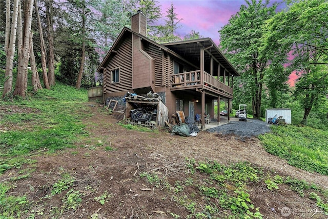 214 Inglewood Dr, Longview, WA 98632 - back of property with a chimney, a wooden deck, and log siding