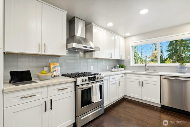 628 163rd Ave SE, Bellevue, WA 98008 - kitchen with wall chimney range hood, appliances with stainless steel finishes, a sink, light countertops, and decorative backsplash