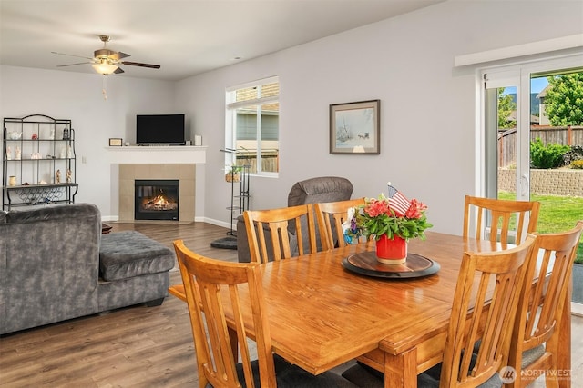 363 Franks Ln N, Enumclaw, WA 98022 - dining area featuring wood finished floors, ceiling fan, and a tiled fireplace