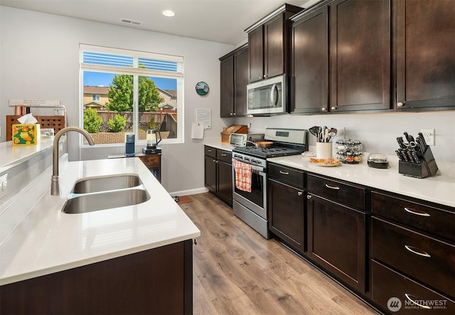 363 Franks Ln N, Enumclaw, WA 98022 - kitchen featuring stainless steel appliances, light wood-type flooring, light countertops, dark brown cabinetry, and recessed lighting