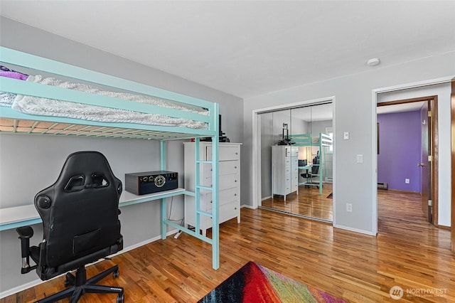 13524 E 5th Ave, Spokane Valley, WA 99216 - bedroom featuring wood finished floors, a desk, a closet, baseboards, and a baseboard radiator
