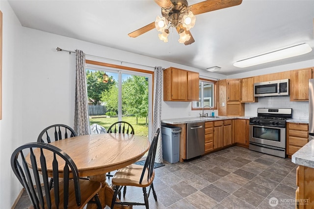13524 E 5th Ave, Spokane Valley, WA 99216 - kitchen with stainless steel appliances, a sink, a ceiling fan, light countertops, and dark stone finish flooring