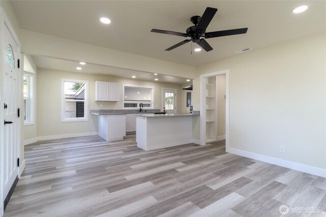 605 Holly St, Walla Walla, WA 99362 - kitchen with white cabinets, light wood-style floors, a sink, recessed lighting, and a peninsula