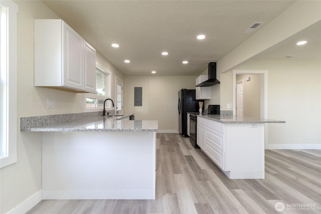 605 Holly St, Walla Walla, WA 99362 - kitchen with black electric range, wall chimney exhaust hood, a peninsula, a sink, and recessed lighting