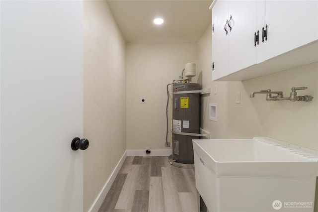 605 Holly St, Walla Walla, WA 99362 - washroom featuring hookup for an electric dryer, washer hookup, secured water heater, cabinet space, and light wood finished floors