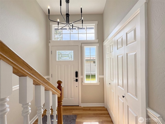 1538 W 12th St, Port Angeles, WA 98363 - entryway featuring a chandelier, light wood finished floors, baseboards, and a textured wall