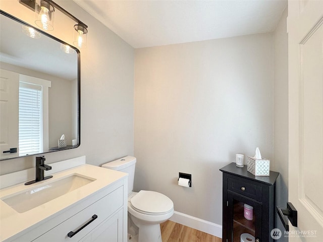 1538 W 12th St, Port Angeles, WA 98363 - bathroom featuring wood finished floors, toilet, vanity, and baseboards