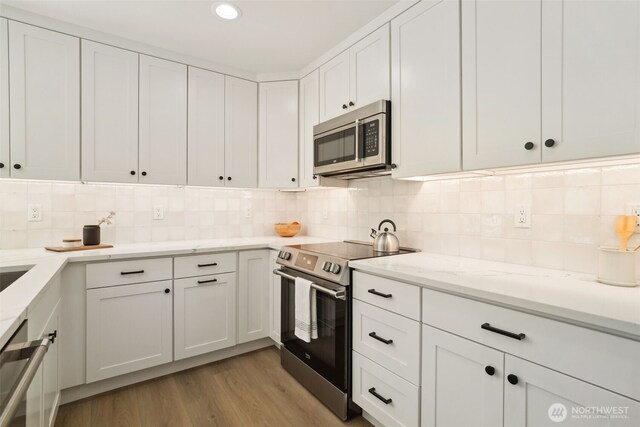 20315 14th Ave NE Unit A & B, Shoreline, WA 98155 - kitchen featuring stainless steel appliances, white cabinetry, light wood finished floors, backsplash, and recessed lighting