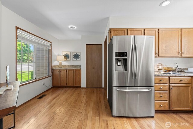 12731 102nd Ave NE, Kirkland, WA 98034 - kitchen with stainless steel fridge with ice dispenser, light wood-style floors, brown cabinetry, light countertops, and recessed lighting