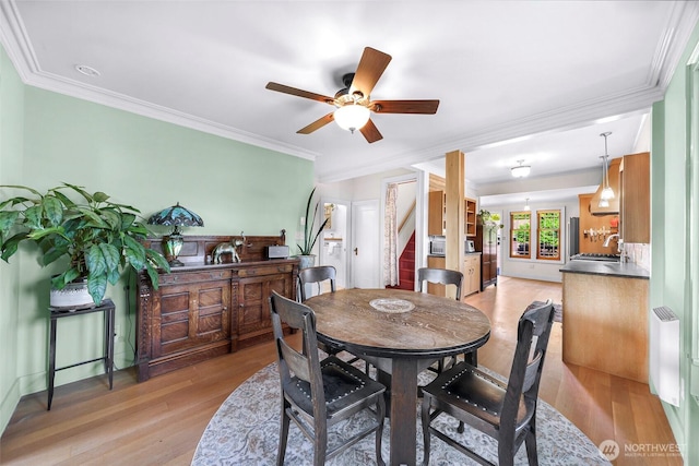2218 Williams St, Bellingham, WA 98225 - dining area featuring crown molding, light wood-style flooring, ceiling fan, and stairs