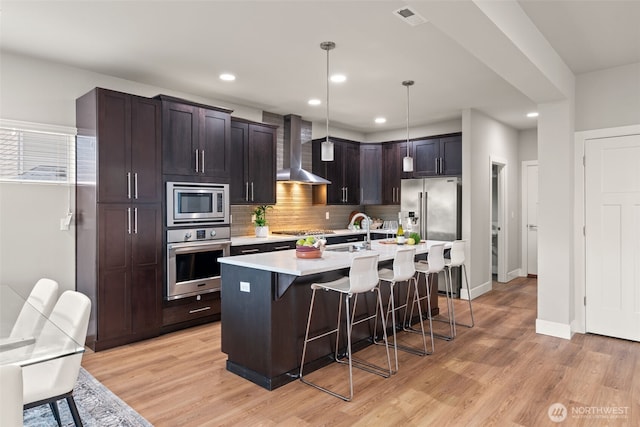 4408 214th Pl SE, Bothell, WA 98021 - kitchen with stainless steel appliances, wall chimney range hood, a sink, a breakfast bar, and light countertops