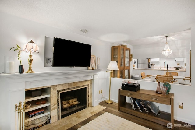 3505 W Government Way Unit 203, Seattle, WA 98199 - living room featuring a tile fireplace, wood finished floors, and baseboards