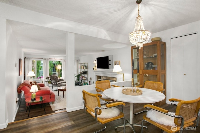 3505 W Government Way Unit 203, Seattle, WA 98199 - dining area with wood finished floors, a tile fireplace, baseboards, and a chandelier