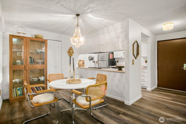 3505 W Government Way Unit 203, Seattle, WA 98199 - dining room with a textured ceiling, dark wood-style floors, baseboards, and a chandelier