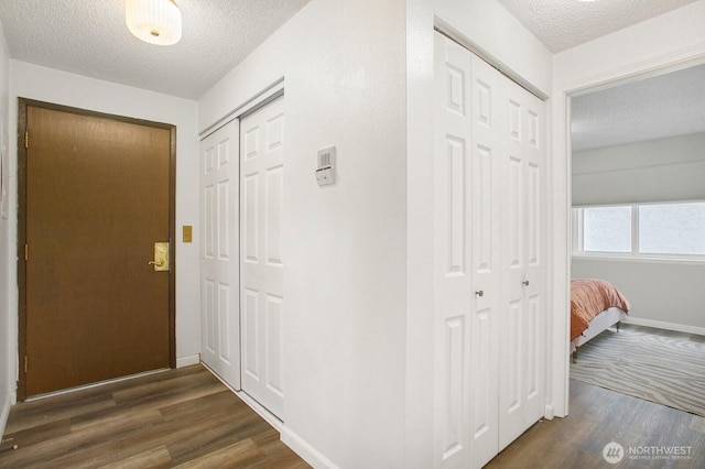 3505 W Government Way Unit 203, Seattle, WA 98199 - hallway with a textured ceiling, dark wood-style flooring, and baseboards