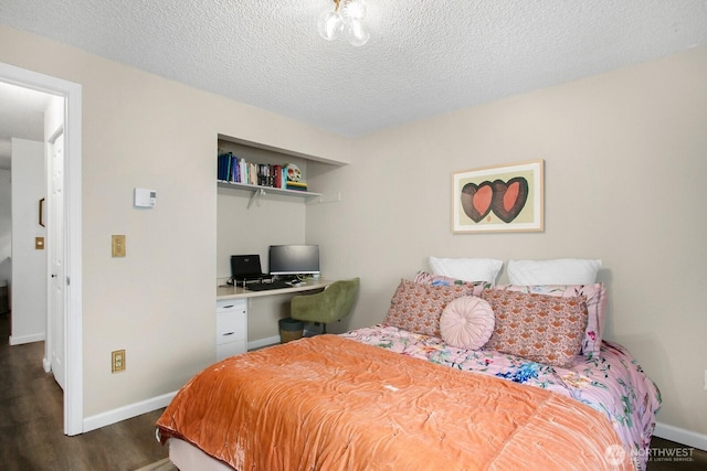 3505 W Government Way Unit 203, Seattle, WA 98199 - bedroom with dark wood-type flooring, a textured ceiling, baseboards, an office area, and a closet