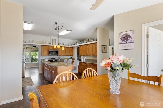 1183 E.9 Rd NE, Moses Lake, WA 98837 - dining room featuring dark wood-type flooring, lofted ceiling, and baseboards