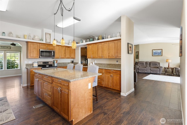 1183 E.9 Rd NE, Moses Lake, WA 98837 - kitchen with stainless steel appliances, a kitchen island, dark wood-style floors, lofted ceiling, and baseboards