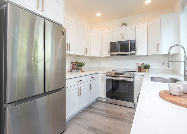 13713 35th Ave NE Unit A, Seattle, WA 98125 - kitchen with appliances with stainless steel finishes, a sink, white cabinetry, recessed lighting, and light stone counters