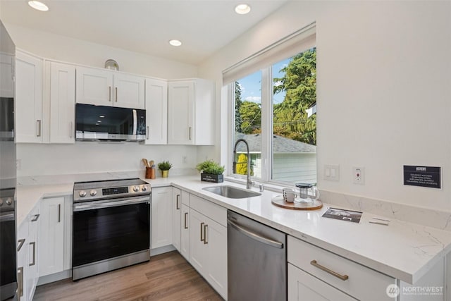 13713 35th Ave NE Unit A, Seattle, WA 98125 - kitchen featuring stainless steel appliances, white cabinets, recessed lighting, and light wood-type flooring