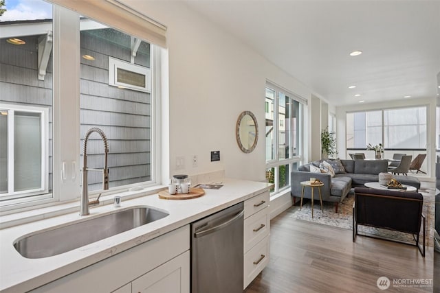 13713 35th Ave NE Unit A, Seattle, WA 98125 - kitchen with stainless steel dishwasher, white cabinets, dark wood finished floors, light stone countertops, and recessed lighting