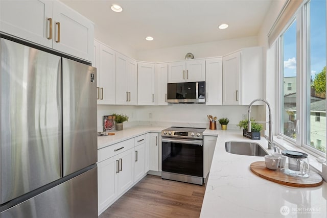 13713 35th Ave NE Unit A, Seattle, WA 98125 - kitchen with appliances with stainless steel finishes, white cabinetry, light stone counters, and recessed lighting