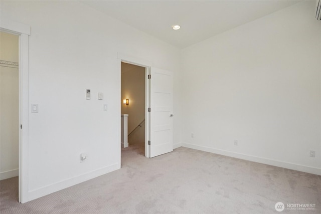 13713 35th Ave NE Unit A, Seattle, WA 98125 - unfurnished bedroom featuring a walk in closet, light carpet, a wall mounted AC, and a closet