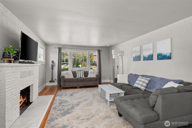 121 SW Alfred Ave, Chehalis, WA 98532 - living area featuring a brick fireplace, wood finished floors, and baseboards