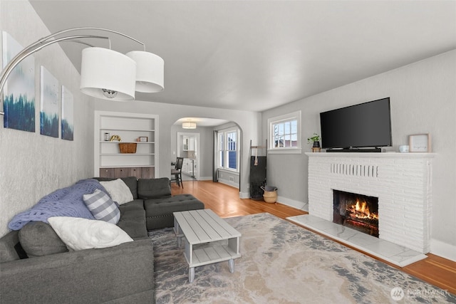 121 SW Alfred Ave, Chehalis, WA 98532 - living room featuring arched walkways, wood finished floors, and a brick fireplace