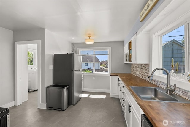 121 SW Alfred Ave, Chehalis, WA 98532 - kitchen featuring wood counters, freestanding refrigerator, a sink, white cabinetry, and healthy amount of natural light