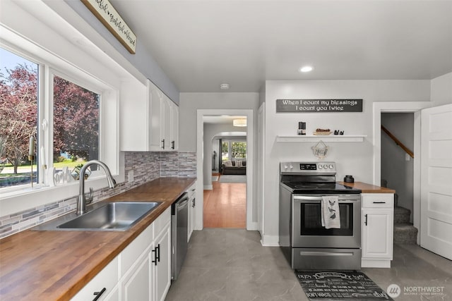 121 SW Alfred Ave, Chehalis, WA 98532 - kitchen with stainless steel appliances, butcher block countertops, a sink, white cabinets, and decorative backsplash