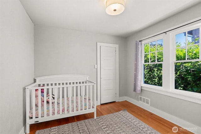 121 SW Alfred Ave, Chehalis, WA 98532 - bedroom with wood finished floors, baseboards, and a nursery area
