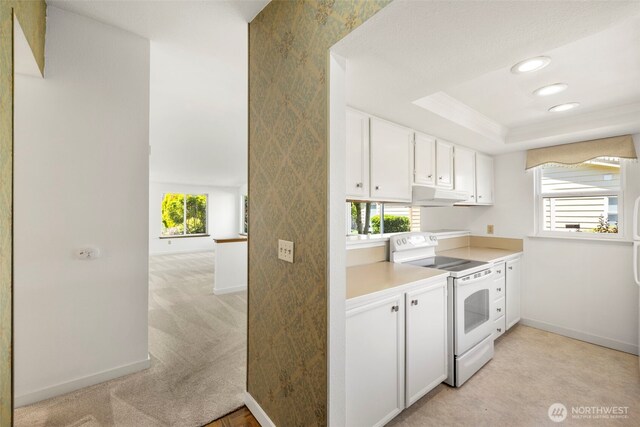 24831 110th Pl SE Unit 51D, Kent, WA 98030 - kitchen featuring white range with electric cooktop, under cabinet range hood, baseboards, healthy amount of natural light, and recessed lighting