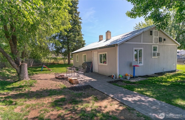 632 Dayton St, Omak, WA 98841 - back of house with an outdoor fire pit, metal roof, and a chimney