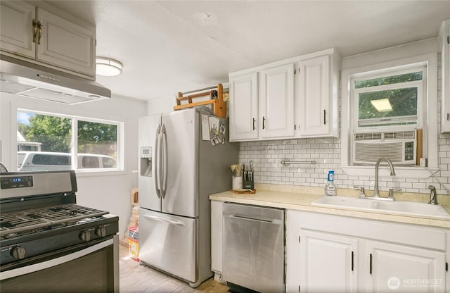 632 Dayton St, Omak, WA 98841 - kitchen with stainless steel appliances, a sink, backsplash, light countertops, and white cabinetry