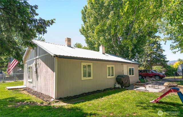 632 Dayton St, Omak, WA 98841 - view of side of home featuring a patio, a chimney, and metal roof