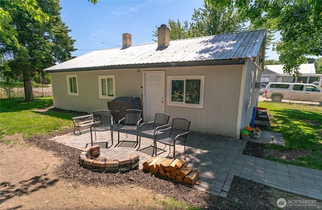 632 Dayton St, Omak, WA 98841 - back of house with a chimney, a patio, a yard, and metal roof